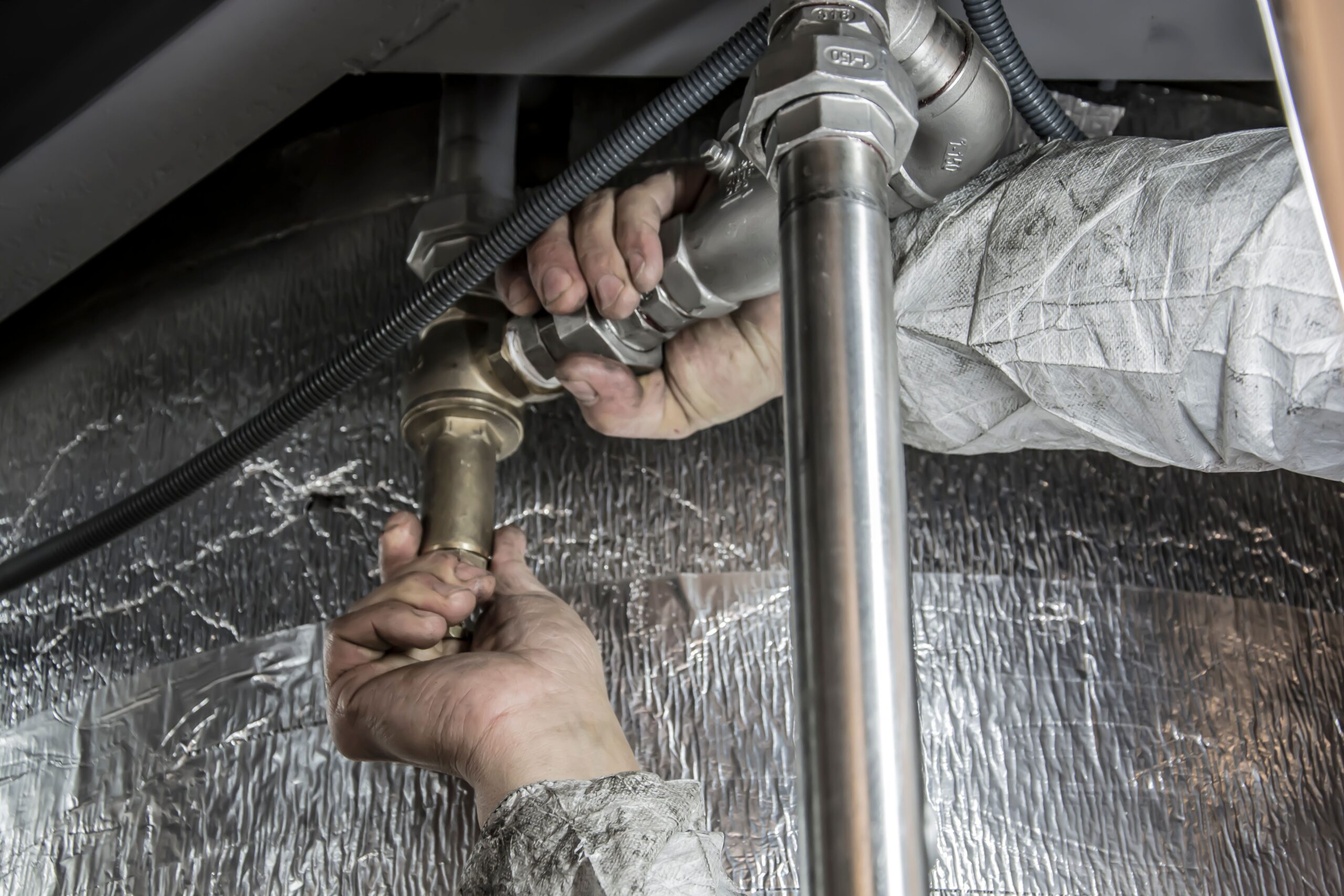 Hands installing pipe fittings during a repair