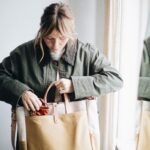 Woman carrying a canvas and leather tote in natural light