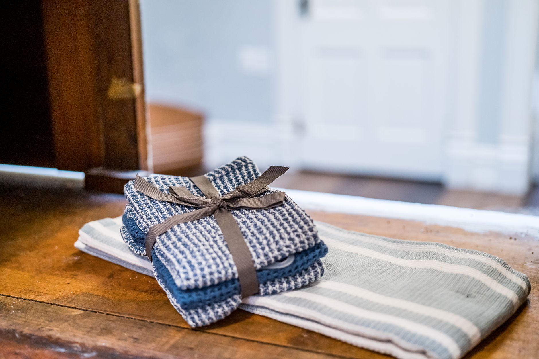 Rustic linen hand towels stacked on a wooden table