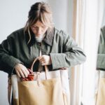 Woman carrying a canvas and leather tote in natural light