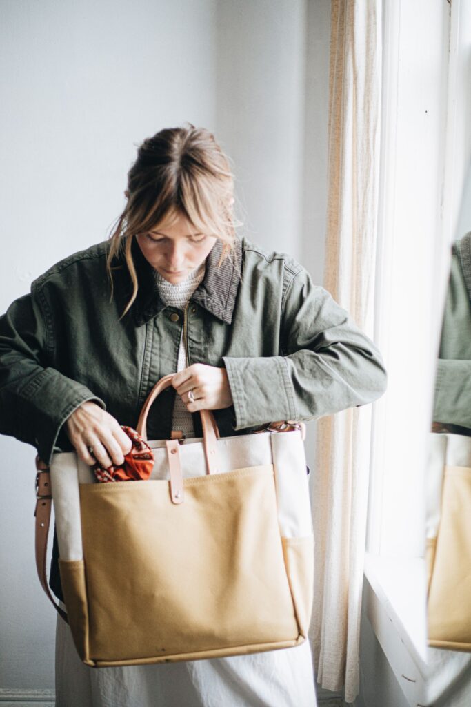 Woman carrying a canvas and leather tote in natural light