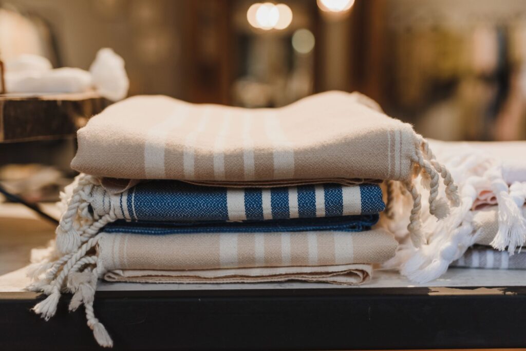 Folded neutral woven textiles in oat and blue stripes